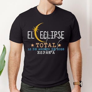 May include: Black t-shirt with the text "EL ECLIPSE TOTAL 12 DE AGOSTO DE 2026 ESPAÑA" in white, yellow, and blue. The design includes a crescent moon and star graphic. The shirt is a crew neck.