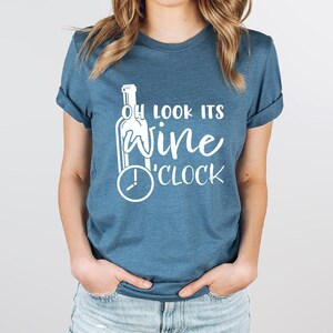 a woman wearing a t - shirt that says, look it's wine clock