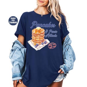 a woman wearing a blue shirt with pancakes on it