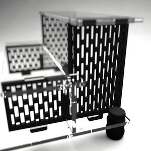 May include: A black and clear acrylic display stand with a tiered design. The stand features a series of rectangular cutouts and a small, black cylindrical object. The design is modern and minimalist.