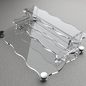 Pode incluir: Uma estante de acr&iacute;lico transparente com um design ondulado e detalhes em metal prateado. A estante tem dois n&iacute;veis e &eacute; suportada por quatro p&eacute;s de metal.
