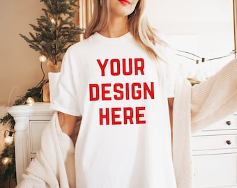 May include: A white t-shirt with the text "YOUR DESIGN HERE" in red lettering.
