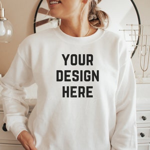 May include: A white sweatshirt with the text "YOUR DESIGN HERE" printed on the front.