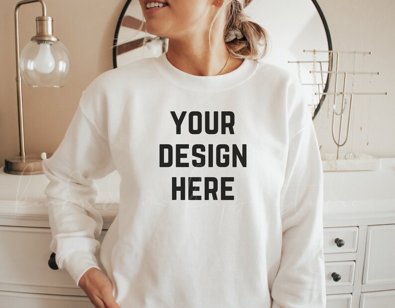 May include: A white sweatshirt with the text "YOUR DESIGN HERE" printed on the front.
