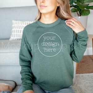 May include: A woman wearing a forest green sweatshirt with the text "your design here" in a white circle on the front.