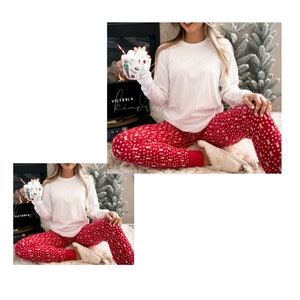 K&ouml;nnte beinhalten: Eine Frau tr&auml;gt ein wei&szlig;es Langarmshirt und eine rote und wei&szlig;e gemusterte Schlafanzughose. Sie h&auml;lt eine Tasse mit Marshmallows in der Hand. Die Tasse hat ein Weihnachtsmotiv.