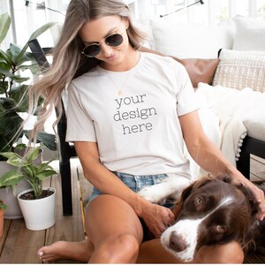 May include: A white t-shirt with the text "your design here" printed on the front. The t-shirt is being worn by a person sitting on a porch with a dog.