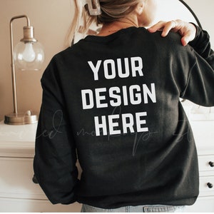 K&ouml;nnte beinhalten: Schwarzer Sweatshirt mit dem Text "YOUR DESIGN HERE" in wei&szlig; auf der R&uuml;ckseite.