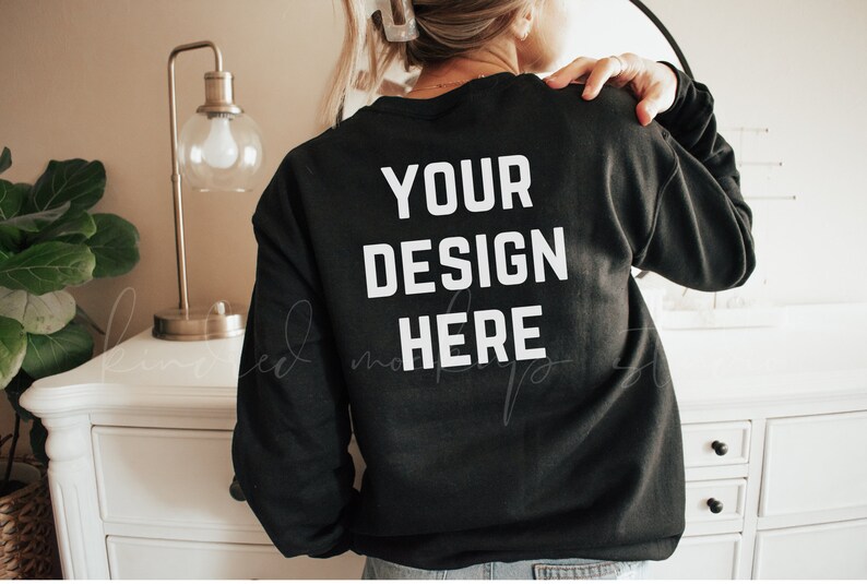 K&ouml;nnte beinhalten: Schwarzer Sweatshirt mit dem Text "YOUR DESIGN HERE" in wei&szlig; auf der R&uuml;ckseite.