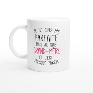 May include: White ceramic mug with black text that reads "Je ne suis pas parfaite mais je suis grand-m&egrave;re et c'est presque pareil". The word "grand-m&egrave;re" is in pink.