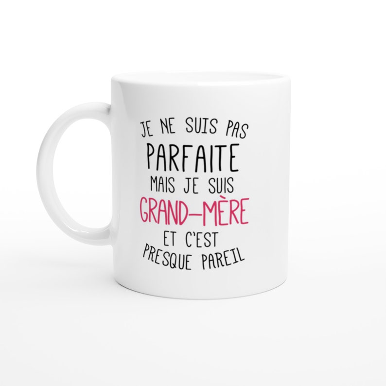 May include: White ceramic mug with black text that reads "Je ne suis pas parfaite mais je suis grand-m&egrave;re et c'est presque pareil". The word "grand-m&egrave;re" is in pink.