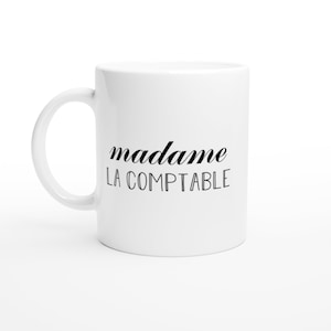 May include: White ceramic mug with black text that reads "madame LA COMPTABLE".