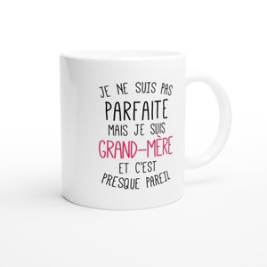 May include: White ceramic mug with black text that reads "Je ne suis pas parfaite mais je suis grand-m&egrave;re et c'est presque pareil". The text "grand-m&egrave;re" is in pink.