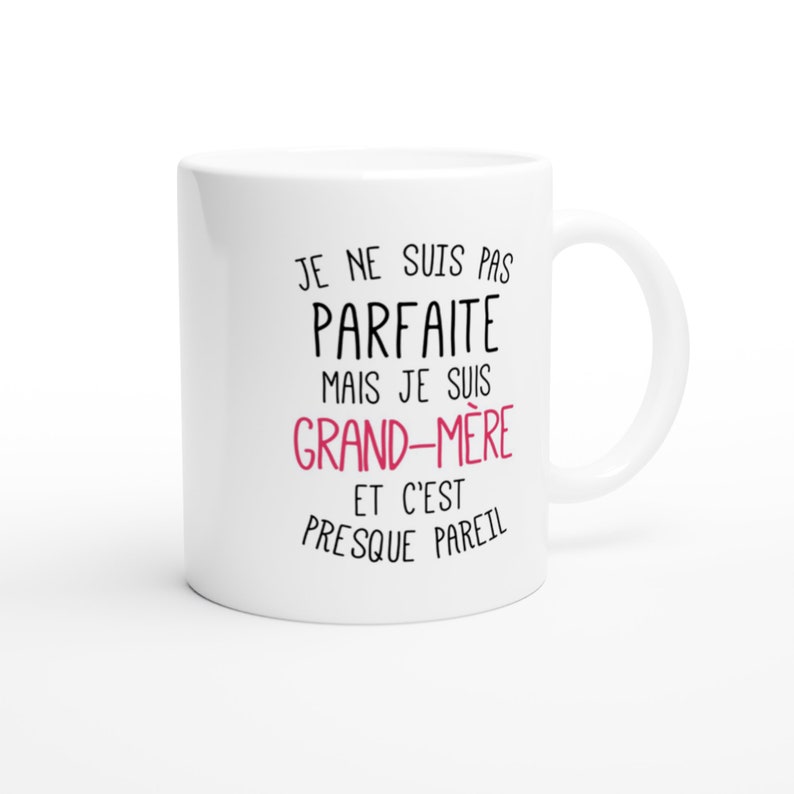 May include: White ceramic mug with black text that reads "Je ne suis pas parfaite mais je suis grand-m&egrave;re et c'est presque pareil". The text "grand-m&egrave;re" is in pink.