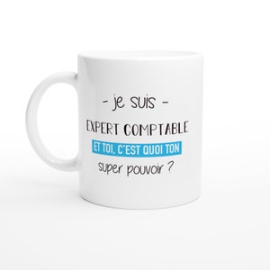 May include: White ceramic mug with a curved handle. The mug features black and blue text in French: "- je suis - EXPERT COMPTABLE ET TOI, C'EST QUOI TON super pouvoir ?" The mug is designed for accountants.