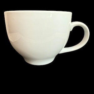 May include: A white ceramic coffee mug with a rounded body and a curved handle. The mug has a smooth, glossy finish and sits on a small, circular base. The background is black.