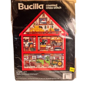 May include: A Bucilla counted cross-stitch kit featuring a red barn with a multi-color chart for easier stitching. The kit is for a busy barn hutch and measures 9" x 12".