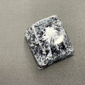 Pu&ograve; includere: Un keycap nero e bianco con un design astratto a spirale. Il keycap &egrave; realizzato in resina trasparente con un motivo nero e bianco incorporato all'interno.