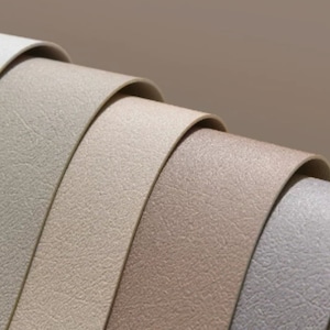 Puede incluir: Primer plano de cinco muestras de tela texturizada en tonos beige, marrón y gris.