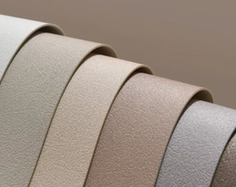 Può includere: Primo piano di cinque campioni di tessuto testurizzato in tonalità beige, marrone e grigio.
