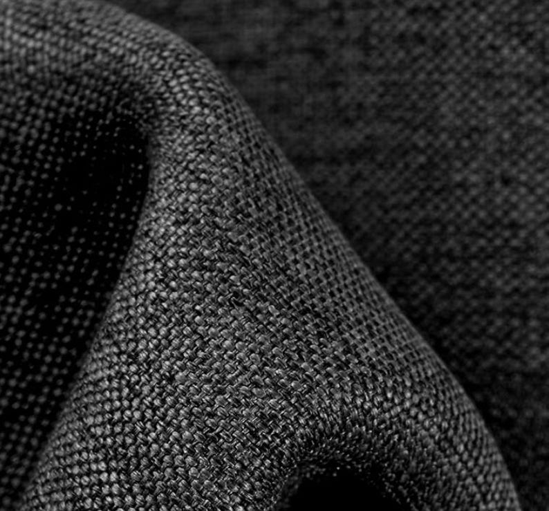 May include: Close-up of a black woven fabric with a textured surface.