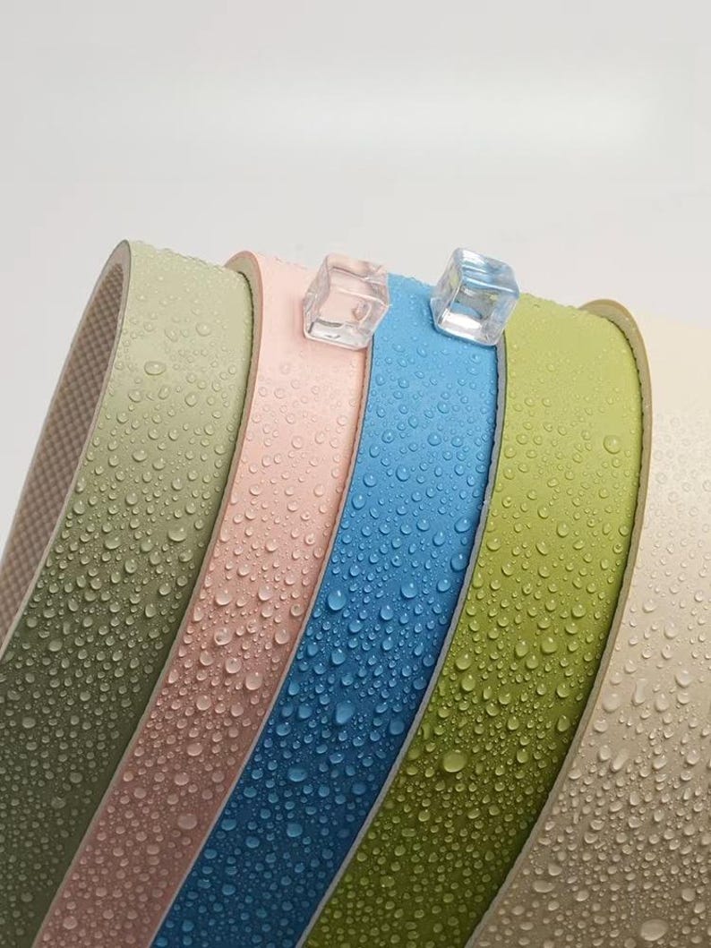May include: Five different coloured rolls of tape with a water-resistant finish. The rolls are stacked on top of each other and have water droplets on them.
