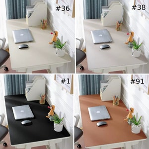 May include: Four different desk mats, each with a laptop, mouse, and decorative figurine. The mats are beige, black, brown, and white.