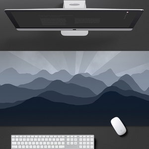 May include: A blue and gray mountain range design printed on a large rectangular mouse pad. The mouse pad is designed to be used with a computer mouse.