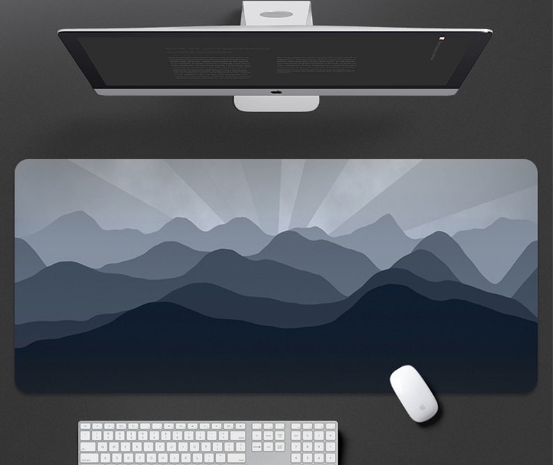 May include: A blue and gray mountain range design printed on a large rectangular mouse pad. The mouse pad is designed to be used with a computer mouse.