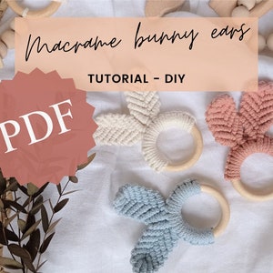 May include: A PDF tutorial for making macrame bunny ears. The image shows three different coloured bunny ears, each with a wooden ring. The text "Macrame bunny ears" and "Tutorial - DIY" are displayed on a peach background.