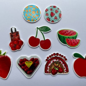 Könnte beinhalten: Eine Sammlung von Aufklebern zum Thema Obst. Enthält Bilder von Orangen, Wassermelonen, Kirschen, Erdbeeren und Äpfeln. Einige Aufkleber haben Text, andere Glitzer. Die Aufkleber befinden sich auf weißem Hintergrund.