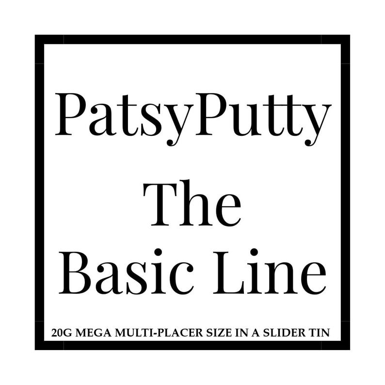 Op de afbeelding: Een vierkant wit label met een dikke zwarte rand met de zwarte tekst PatsyPutty The Basic Line. Daaronder staat de tekst 20G MEGA MULTI-PLACER SIZE IN A SLIDER TIN. Het ontwerp is eenvoudig, strak en maakt gebruik van een schreeflettertype.