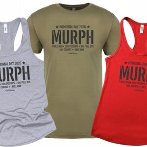 May include: Three athletic shirts in gray, olive green, and red. Each shirt features the text "MURPH" with "Memorial Day 2026" and workout details. The shirts are a tank top and a crew neck tee.