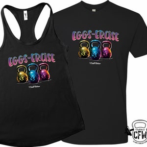 May include: Black tank top and t-shirt featuring the text "EGGS-ERCISe" in a rainbow gradient. Below the text are three colorful kettlebells. The brand name "ClubFitWear" is printed below the kettlebells.
