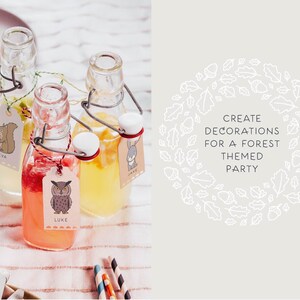 May include: Three glass bottles with cork tops and wire closures filled with a clear liquid. Each bottle has a paper tag with a woodland animal illustration and a name: Eva, Luke, and Jake. The bottles are on a white and brown striped surface. The text "CREATE DECORATIONS FOR A FOREST THEMED PARTY" is in a white circle with a white outline of leaves and acorns.