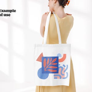Puede incluir: Bolsa de tela blanca con un dise&ntilde;o abstracto colorido que incluye un tri&aacute;ngulo rojo, un c&iacute;rculo azul y formas rosas y rojas. El dise&ntilde;o tambi&eacute;n incluye una hoja roja y azul.