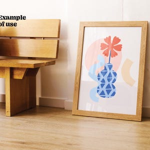 Puede incluir: Una impresi&oacute;n de arte abstracto enmarcada con un jarr&oacute;n estampado en azul y blanco, una flor roja y formas rosadas y amarillas.