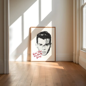 May include: A black and white poster with a portrait of a man with slicked back hair. The text "Doin' Fine For Being Young" is printed in red on the poster.