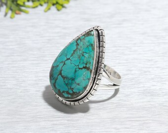 May include: A teardrop-shaped turquoise gemstone ring set in sterling silver. The ring features a detailed silver band with a textured design.