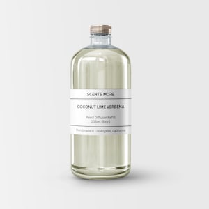 May include: A clear glass bottle with a gold lid filled with a light yellow liquid. The label reads "SCENTS MORE COCONUT LIME VERBENA Reed Diffuser Refill 236ml (8 oz) Handmade in Los Angeles, California."
