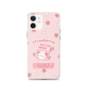 May include: A pink phone case with a cartoon bunny on a carton of strawberry milk. The case has a white border and a repeating pattern of strawberries and flowers. The text "strawberry milk" and "いちごミルク" is printed on the case.