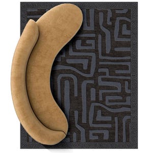 Op de afbeelding: Een bruin, gebogen bankstel staat op een donkergrijs tapijt met een geometrisch doolhofpatroon. Het tapijt heeft een rand met een herhalend Grieks sleutelontwerp. De vorm van de bank doet denken aan een halve maan.