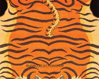 May include: Orange and black tiger-shaped rug. The rug features a detailed tiger design with orange and black stripes, a face, and paws. The background is black, and the text "RUGSCOLLECTIONSHOP" is visible.