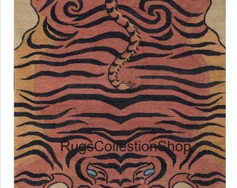 May include: A rectangular rug featuring a tiger design. The rug has a beige background with a large tiger illustration in shades of orange, black, and yellow. The tiger's stripes and facial features are clearly defined.