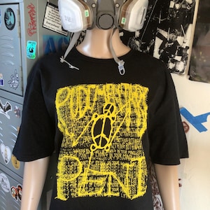 May include: Black t-shirt with a yellow graphic print that says "POINT OF LIVING IN YOUR MINDLESS LIFE" and "POINT OF DYING IN YOUR MINDLESS LIFE".