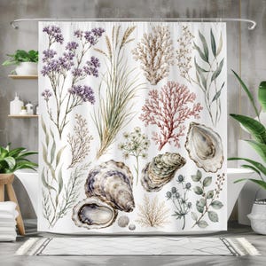 May include: A white shower curtain featuring a botanical and coastal print with purple wildflowers, tall grasses, beige coral, pink sea fan, green eucalyptus leaves, and several textured oyster shells arranged across the fabric surface.
