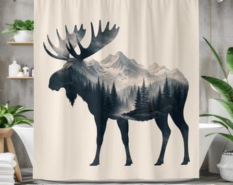 May include: A cream-coloured shower curtain featuring a large, dark silhouette of a moose. The interior of the moose shape displays a detailed landscape of a dense pine forest and snow-capped mountains under a cloudy sky, rendered in shades of grey.
