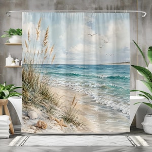 Könnte beinhalten: Duschvorhang mit einer ruhigen Strandszene. Das Kunstwerk zeigt einen sandigen Strand mit Muscheln, Strandhafer und einem ruhigen Ozean unter einem bewölkten Himmel. Möwen segeln über den Wellen und schaffen eine beruhigende Küstenatmosphäre.