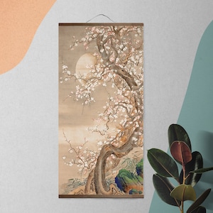 May include: A vintage Japanese woodblock print depicting a blossoming cherry tree with white flowers against a pale background. The tree is depicted with a thick trunk and branches reaching up and out, creating a sense of movement and growth. The print is framed with a simple wooden frame.