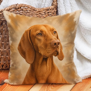 Könnte beinhalten: Ein quadratisches Zierkissen mit einem detaillierten Porträt eines goldbraunen Vizsla-Hundes. Der Hund ist mit leicht nach rechts gedrehtem Kopf dargestellt und zeigt sein glattes Fell, die Schlappohren und bernsteinfarbenen Augen vor einem Hintergrund.